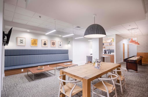 a conference room with a table and chairs and a blue couch