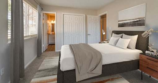 A bedroom with a large bed and a painting on the wall.
