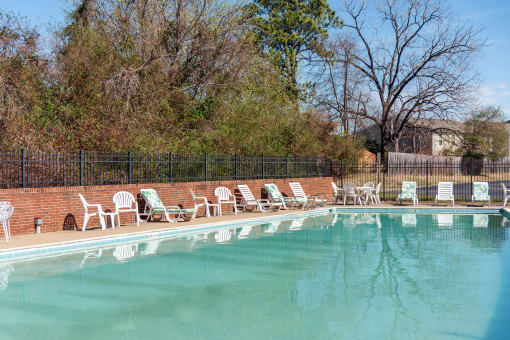 a swimming pool with chairs and chairs around it