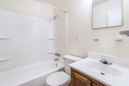 A white bathroom with a toilet, sink, and bathtub.
