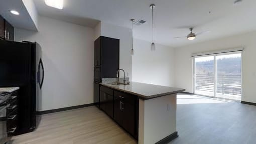 an empty kitchen with a refrigerator and a sink