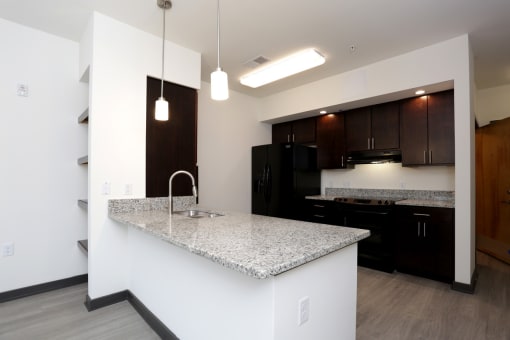 a kitchen with black appliances and a granite counter top