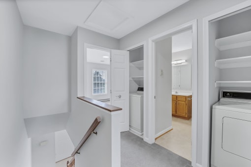 a laundry room with a washer and dryer and a door to a bathroom