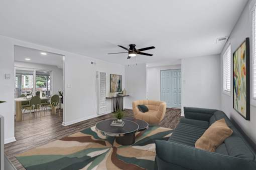 A living room with a green couch and a rug with a leaf pattern.
