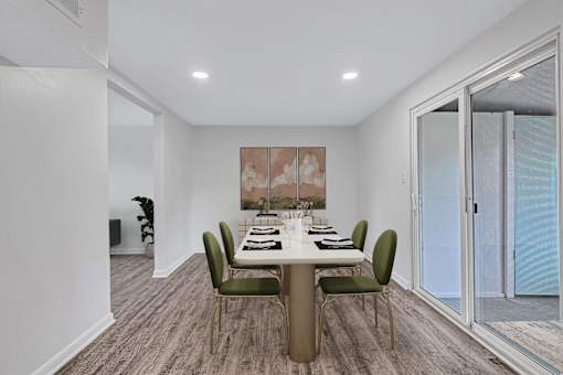 A dining room with a table set for six people.