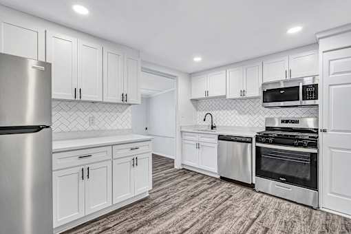 A modern kitchen with white cabinets and stainless steel appliances.