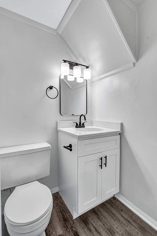 A white toilet sits next to a white sink in a small bathroom.