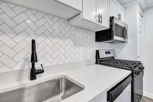 A modern kitchen with a black oven and a black microwave above it.