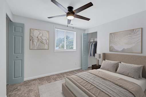 A bedroom with a large bed and a ceiling fan.