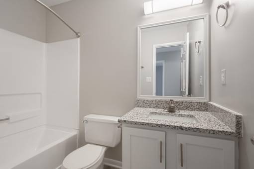 A white bathroom with a sink, toilet and bathtub.