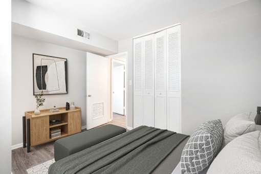 A bedroom with a bed, a nightstand, and a wardrobe.