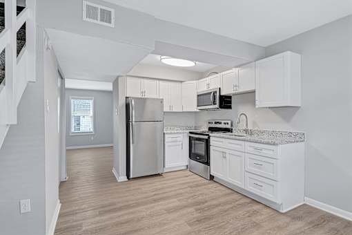 A kitchen with white cabinets and stainless steel appliances.