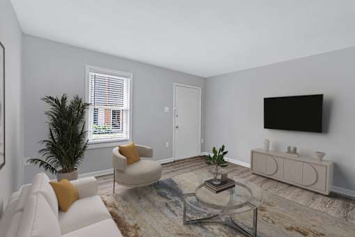 A living room with a white couch, a glass coffee table, and a flat screen TV mounted on the wall.