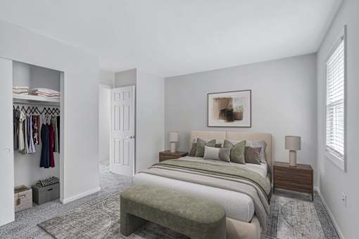 A bedroom with a large bed and a clothing closet.
