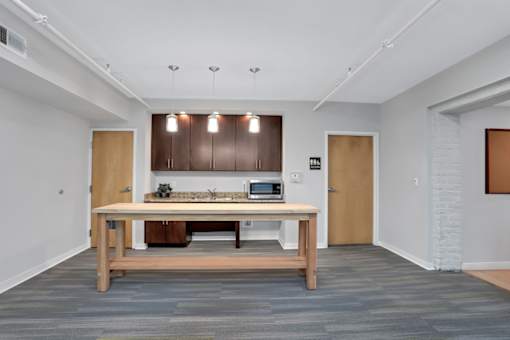 a kitchen with a wooden table in the middle of a room