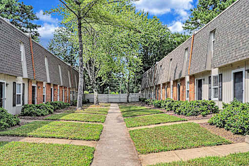A long, narrow walkway separates two rows of identical houses.