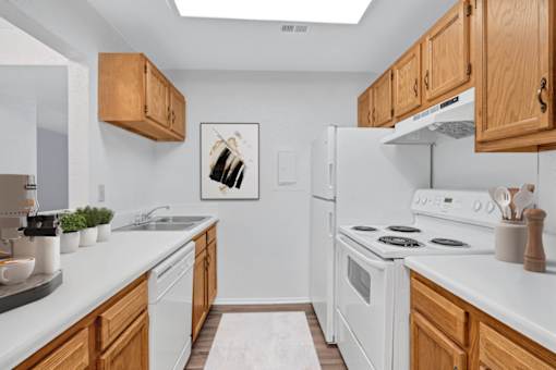 A kitchen with white appliances and wooden cabinets.
