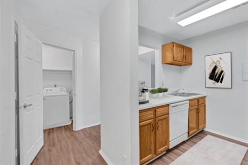 A kitchen with white appliances and wooden cabinets.