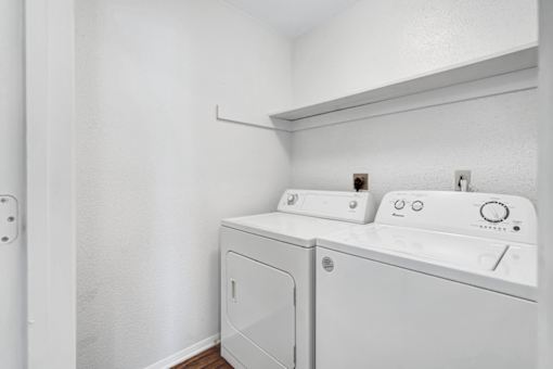 A white washing machine and dryer in a small laundry room.