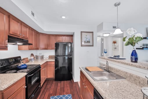 a kitchen with granite counter tops and a black refrigerator