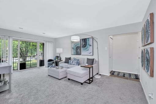 a living room with grey carpet and white walls