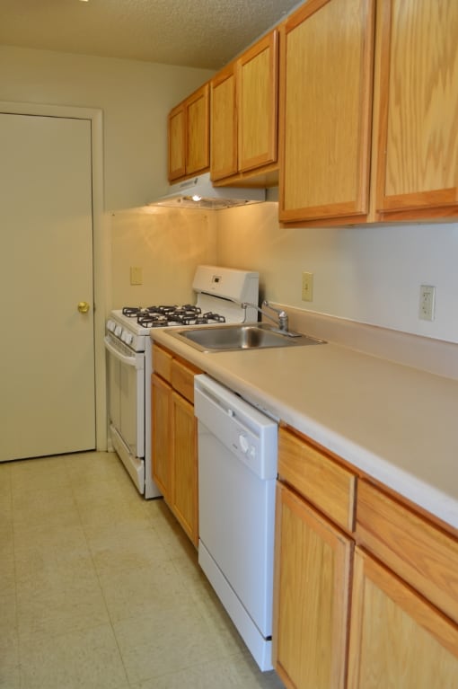 a kitchen with white appliances and wooden cabinets