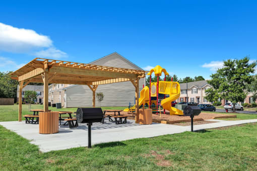 a playground and pavilion in a park with a yellow