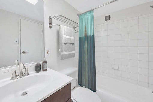 a white bathroom with a shower and a sink
