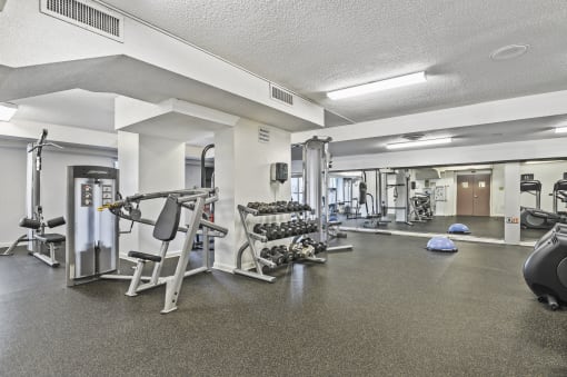 a gym with exercise equipment and weights on the floor