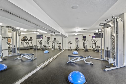 a fitness room with weights and cardio equipment at the grove apartments