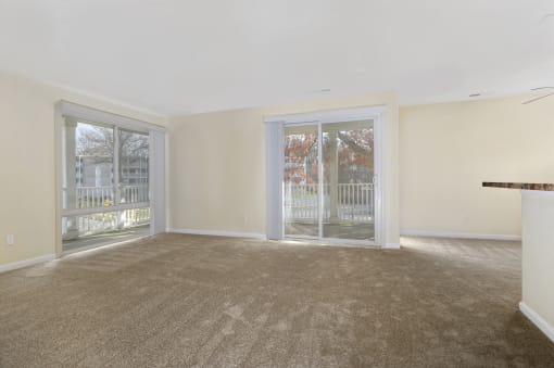an empty living room with sliding glass doors to a balcony