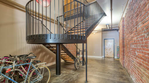 a spiral staircase in a loft with bikes parked under it