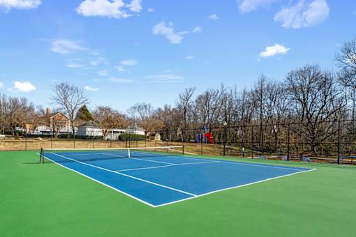 A blue and green tennis court with a white line down the middle.