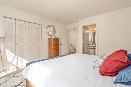 A bedroom with a large bed and a mirror on the wall.