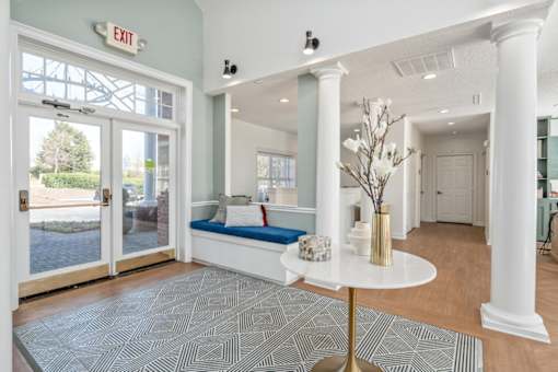 A white room with a round table and a bench under a window.