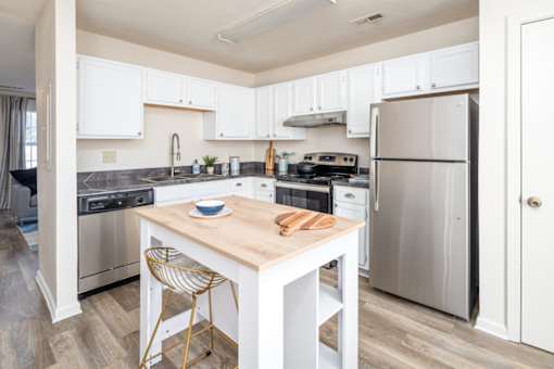A kitchen with a table and chairs in the middle.