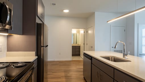 a kitchen with an island and a sink and a refrigerator