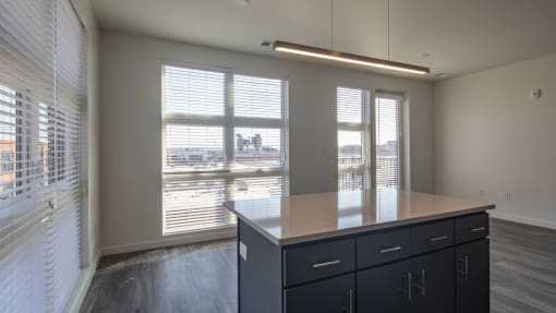 a view of a dining room with a large window and a table with black cabinets
