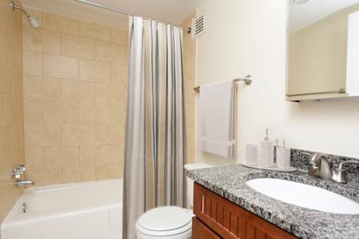 A bathroom with a white tub, toilet, and sink.