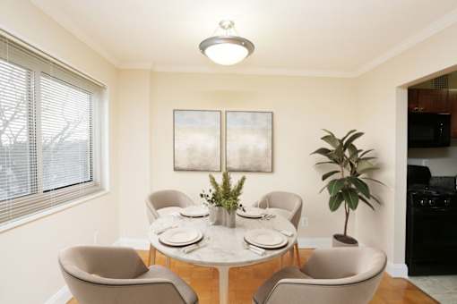 A dining room with a white table and chairs.