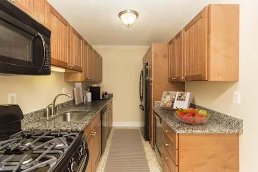 A kitchen with wooden cabinets and granite countertops.