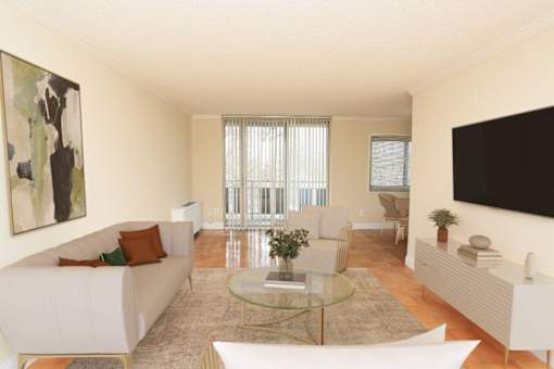 A living room with a white couch and a glass coffee table.