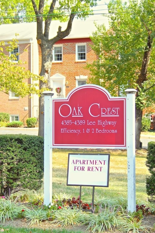 a sign in front of a building that reads oak crest apartments