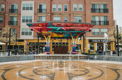 A fountain in front of a building with a canopy over it.