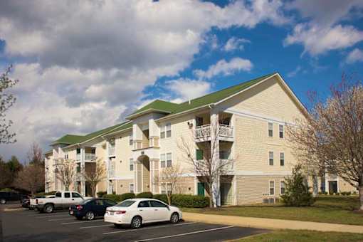 a large apartment building with cars parked in a parking lot