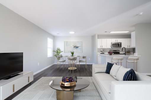 A modern living room with a white sofa and a glass coffee table.