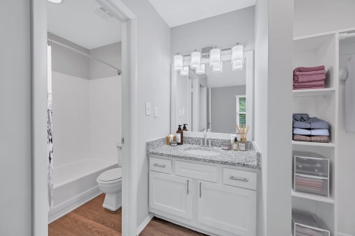 a bathroom with white walls and a white toilet next to a white bathtub