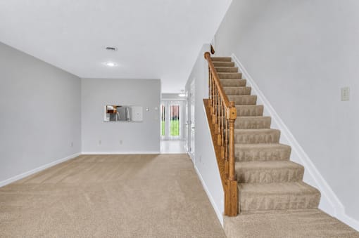 A staircase with a wooden handrail leads up to a second floor.