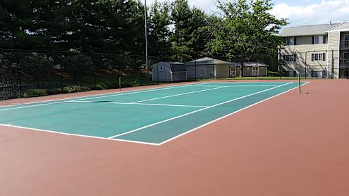 A tennis court with a green surface and white lines.