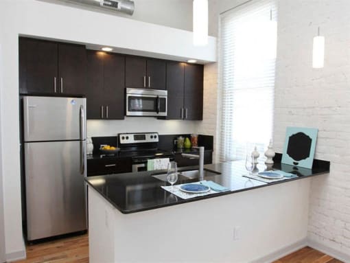 a kitchen with a counter and a stainless steel refrigerator